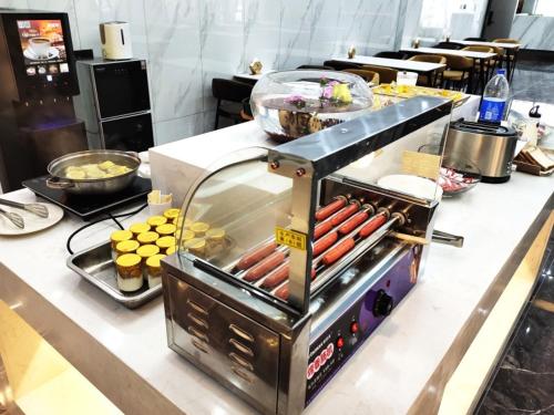 a grill with hot dogs and other food on a counter at GreenTree Eastern Hotel Huai'an University in Huai'an