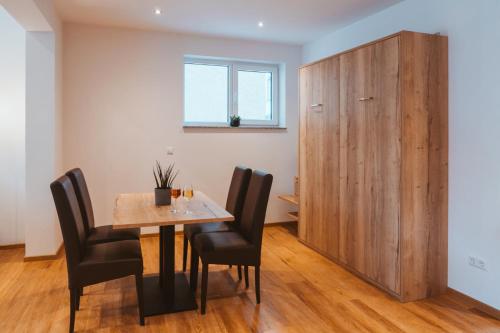 a dining room with a table and chairs and a wooden cabinet at Ferienweingut SerwaziWein in Mesenich