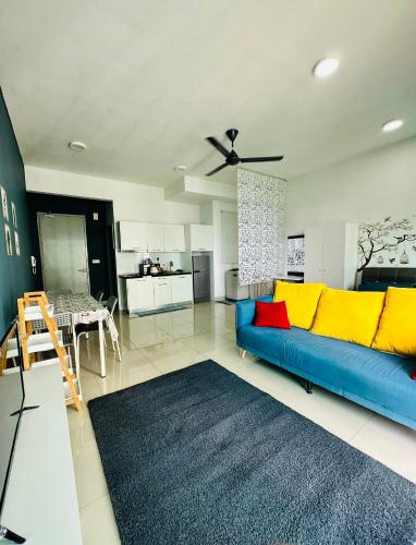 a living room with a blue couch and a kitchen at Bella Homestay by AK Group in Cyberjaya