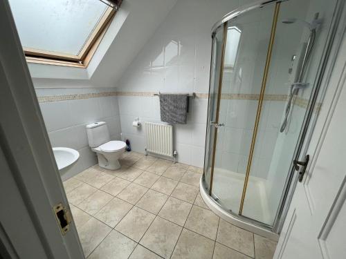 a bathroom with a toilet and a glass shower at Dovecote Lodge on the 5 star Lough Erne Resort in Ballycassidy