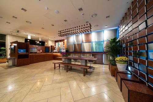 a large lobby with a table and a kitchen at Hotel DM in Seoul