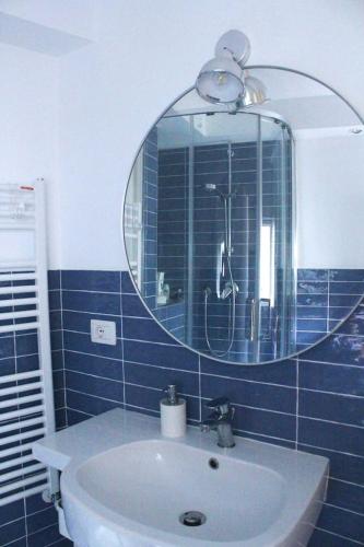 a blue tiled bathroom with a sink and a mirror at CasaMare. Orbetello centro storico. in Orbetello
