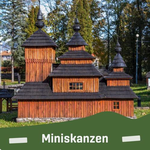a wooden building with four domes on top of it at Vaclavskeho Apartment Medzilaborce in Medzilaborce