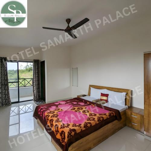 Hotel SAMARTH PALACE في ماهاباليشوار: غرفة نوم بسرير ومروحة سقف