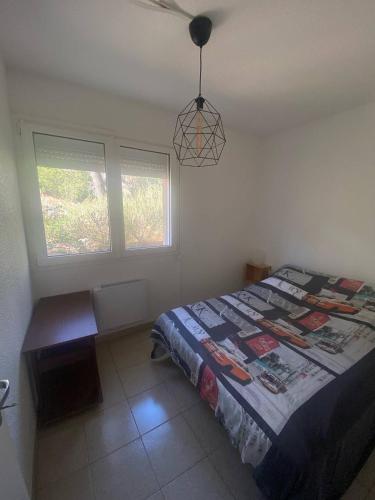 une chambre avec un lit et deux fenêtres dans l'établissement T2 à 200m de la plage avec balcon avec WIFI, à Saint Pierre La Mer