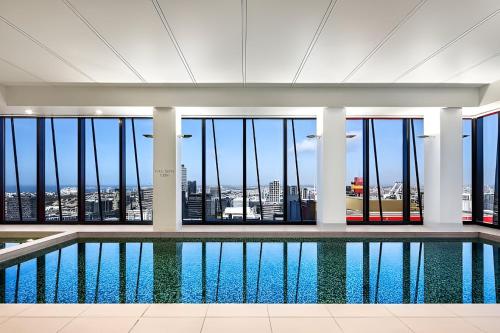 a swimming pool in a building with a view of the city at Quick Aces Premium in Melbourne