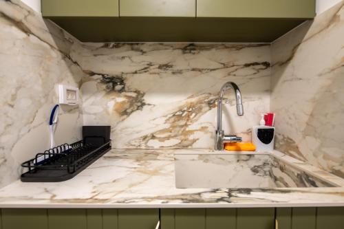 a marble kitchen counter with a sink and a faucet at Beach Side- Ceasar Luxury Amazing Pool Eilat in Eilat