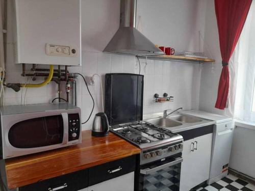 a small kitchen with a microwave and a stove at Mieszkanie Warszawska 5 in Giżycko