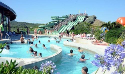 un groupe de personnes nageant dans une piscine dans l'établissement Beau pavillon T4 à 100m de la plage, à Saint Pierre La Mer
