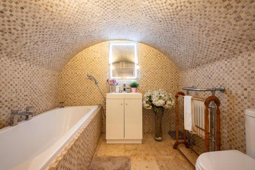 a bathroom with a bath tub and a toilet at NIRU Experience Hidden Gem In Chelsea in London