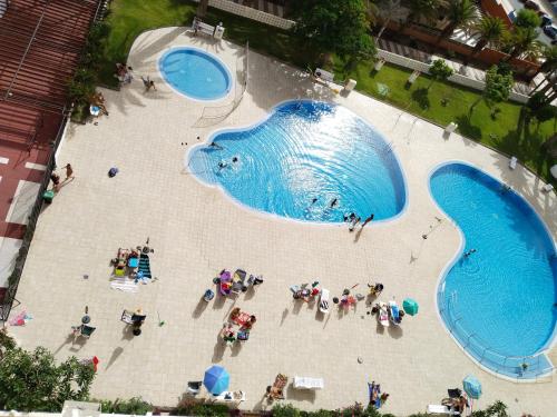 a group of people standing around a swimming pool at Los Cristianos appartement Lemon trees vue mer panoramique in Los Cristianos