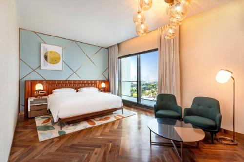 a bedroom with a bed and a large window at Hyatt Centric Jumeirah Dubai in Dubai