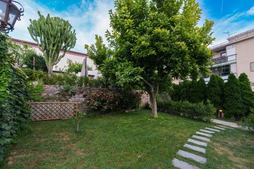 a garden with a tree and a stone pathway at AGAVE B&B in Vico Equense
