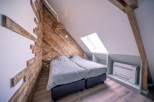 a bed in a room with a wooden wall at Salty Vibes in Middelkerke