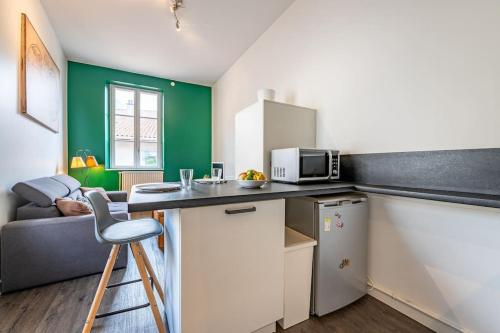 a small kitchen with a counter and a microwave at Entre Bastille et hyper-centre: lave-linge - fibre in Grenoble