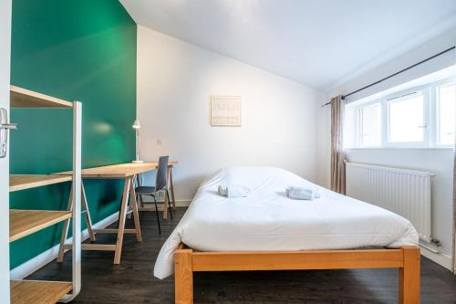 a bedroom with a bed and a table and a desk at Entre Bastille et hyper-centre: lave-linge - fibre in Grenoble