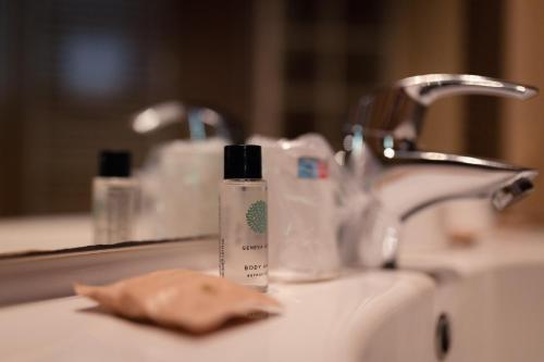 - un lavabo avec une bouteille de savon et une serviette dans l'établissement VVF Serre Chevalier Briançon, au Monêtier-les-Bains