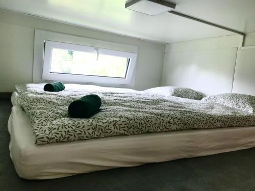 a bedroom with a large bed with two pillows on it at TinyHouse & Garden in Geceľ