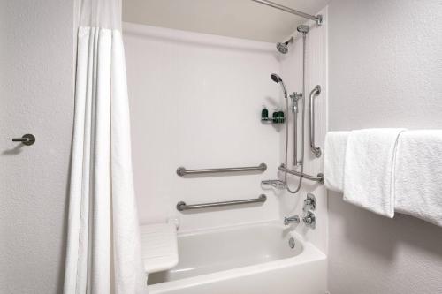 a bathroom with a shower and a bath tub with towels at Courtyard by Marriott Oklahoma City Northwest in Oklahoma City