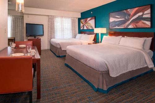 a hotel room with two beds and a flat screen tv at Residence Inn Fairfax Merrifield in Merrifield