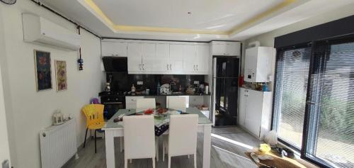 eine Küche mit weißen Schränken sowie einem Tisch und Stühlen in der Unterkunft Albatros in Büyükçekmece