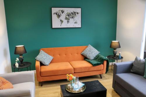 an orange couch in a living room with a blue wall at Stylish townhouse-Central location-Great discoun s in Milton Keynes