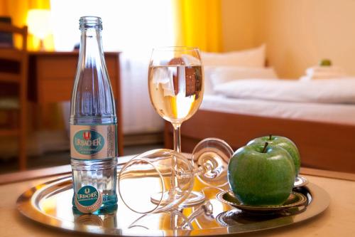 a tray with a bottle of wine and an apple on a table at Hotel Abendstern in Berlin