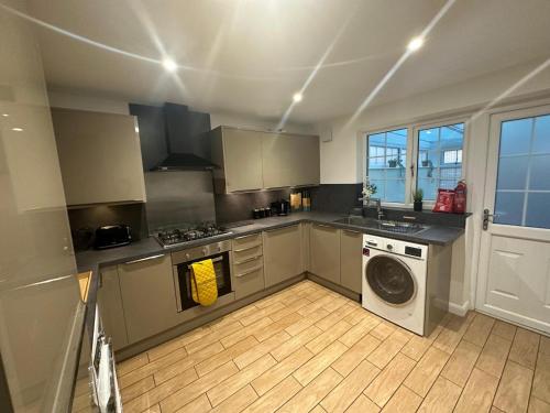 eine Küche mit Waschmaschine und Waschmaschine in der Unterkunft Stylish townhouse-Sleeps 9-Free parking in Milton Keynes