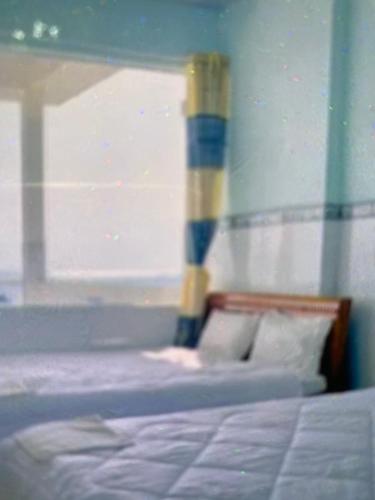 Cama en habitación con ventana y cama sidx sidx en Vân tiến, en Rạch Giá