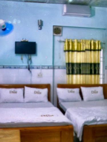 a room with two beds and a tv in it at Vân tiến in Rạch Giá