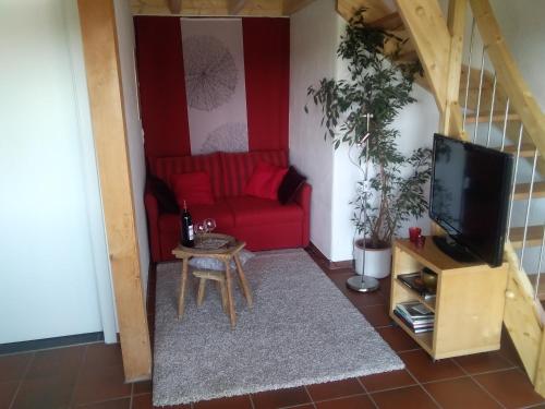 a living room with a red couch and a tv at Wohnung mit Ausblick in Ravensburg