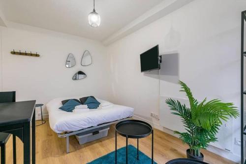 - une chambre avec un lit, un bureau et une plante dans l'établissement Le Little Blue : au coeur du centre historique, à Dijon