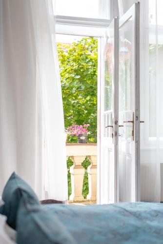 an open door with a flower pot on a balcony at Prague - Karlin Apartments in Prague