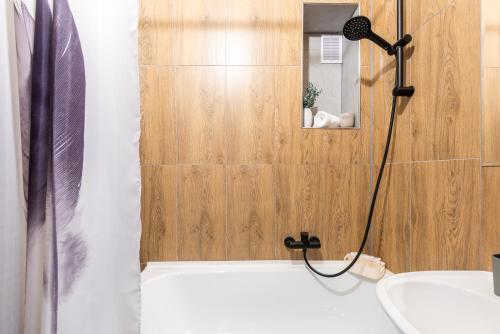a bathroom with a shower and a tub and a sink at Prague - Karlin Apartments in Prague