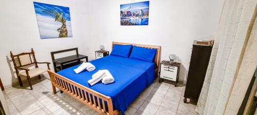 ein Schlafzimmer mit einem blauen Bett und Handtüchern darauf in der Unterkunft Appartamento Akesines in Trappitello