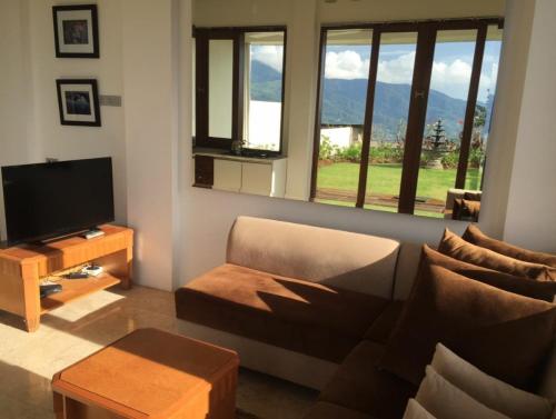 a living room with a couch and a television at De Summit Villa & View in Puncak