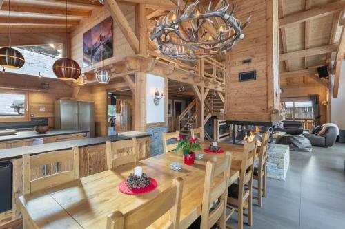 a kitchen and dining room with a wooden table and chairs at Chalet Carnauba in Châtel