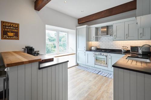 une cuisine avec des armoires blanches et un comptoir dans l'établissement Host & Stay - River View Cottage, à Barnard Castle