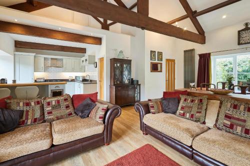 a living room with two couches and a kitchen at Host & Stay - River View Cottage in Barnard Castle