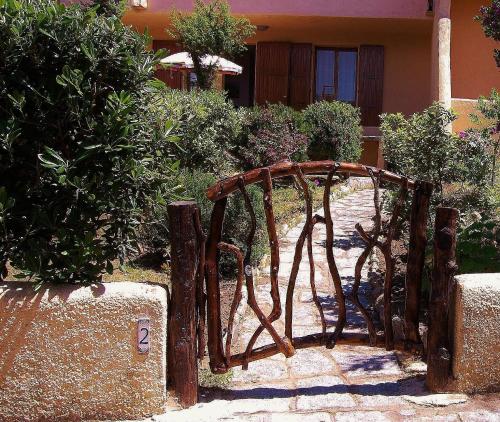 um portão de madeira em frente a uma casa em La Casetta Nella Baia em Santa Teresa Gallura