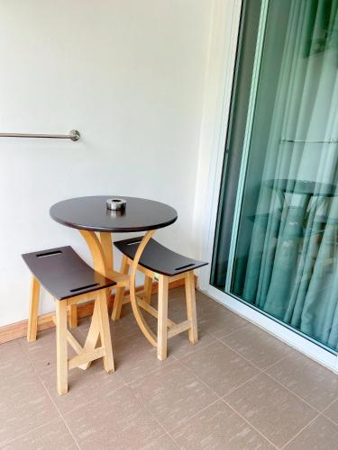 a table and two chairs sitting next to a window at Tanatnan Hotel in Ranong