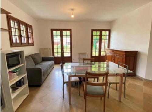 een woonkamer met een glazen tafel en een bank bij Appartement F2 in Mantes-la-Ville