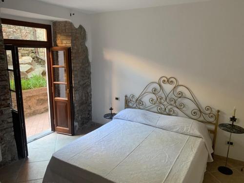 1 dormitorio con cama blanca y puerta de cristal en Il Mulino Del Tempo Perduto, en Bagnone