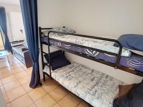 une chambre avec deux lits superposés dans une pièce dans l'établissement Jolie studio, à Saint Pierre La Mer