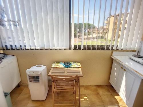 une petite cuisine avec une table et une fenêtre dans l'établissement Jolie studio, à Saint Pierre La Mer
