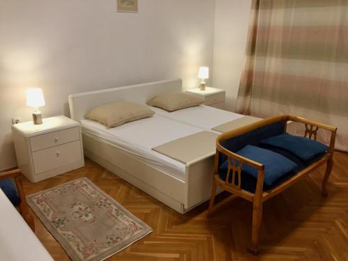 una camera con un letto e una sedia e due lampade di Guest House Gaj Sarajevo a Sarajevo