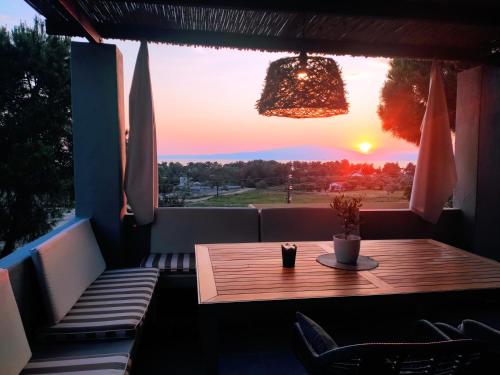 a table on a balcony with a view of the sunset at Pernakria in Skala Rachoniou