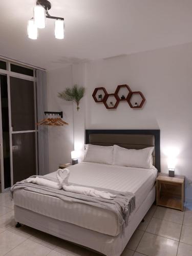 a bedroom with a large bed with two glasses on the wall at Bonsai Jacuzzi Suites in Panglao