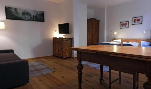 a bedroom with a bed and a desk with a television at Ferienwohnung Scheffelhaus in Gengenbach