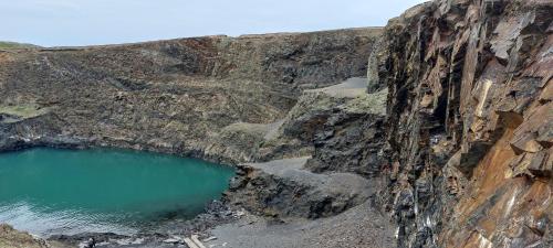 a quarry with a blue pool of water on a cliff at Raymond House Guest House Penally in Penally